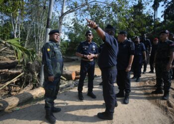 RAZARUDIN Husain (dua kiri) mendengar taklimat daripada Ketua Polis Daerah Baling, Superintenden Shamsudin Mamat ketika melawat lokasi tragedi kepala air dan banjir lumpur di Kampung Iboi, Kupang, Baling, Kedah. -UTUSAN/IQBAL HAMDAN
