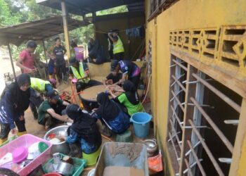 SUKARELAWAN mencuci perkakasan dapur yang kotor akibat kejadian kepala air di Sungai Iboi, Baling, Kedah. - UTUSAN/IQBAL HAMDAN