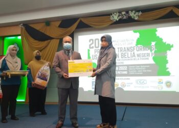 TARMIZI Mukhtar menyampaikan replika cek pencen bulanan kepada Maimon Ismail hasil caruman Allahyarham suaminya yang meninggal akibat Covid-19 di Wisma Perkeso di Kuantan, Pahang. - FOTO/ DIANA SURYA ABD WAHAB