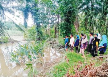 PENDUDUK melihat keadaan air sungai yang mengalir masuk ke Kampung Kunci Air 12 di Pasir Salak, Perak, baru-baru ini. - UTUSAN/AIN SAFRE BIDIN