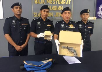 MOHD. Haki Hasbullah (dua dari kanan) bersama pegawainya menunjukkan sepucuk pistol jenis Revolver S/W 357 Magnum Smith/Wesson bersama enam butir peluru yang dirampas daripada seorag lelaki dalam sidang akhbar di Ibu Pejabat Polis Daerah (IPD) Tanah Merah, Kelantan, hari ini. -UTUSAN/ROSMIZAN RESDI