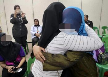 AMIRAH (kanan) memeluk erat kakaknya yang hadir pada program PBSL di Penjara Pusat Kota Kinabalu, semalam.