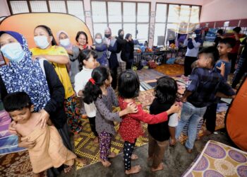 MANGSA banjir di PPS Sekolah Kebangsaan (SK) Felda Sungai Kelamah, Tampoi melakukan sesi senaman ringan yang dikendalikan Pegawai Kesihatan Daerah Tampin. -UTUSAN/MOHD. SHAHJEHAN MAAMIN