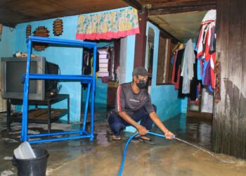 PENDUDUK kampung Teluk Kumbar, Pulau Pinang membersihkan rumah masing-masing daripada sisa banjir selepas air mulai surut sepenuhnya hari ini.