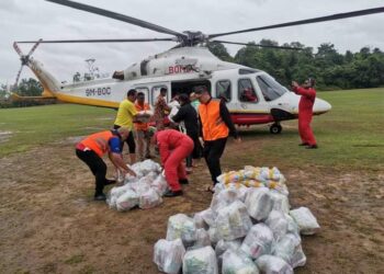 ANGGOTA bomba dan petugas banjir  menguruskan penghantaran bantuan bekalan makanan untuk mangsa yang terputus hubungan di tiga buah kampung di Rompin, Pahang. - FOTO/IHSAN JBPM PAHANG