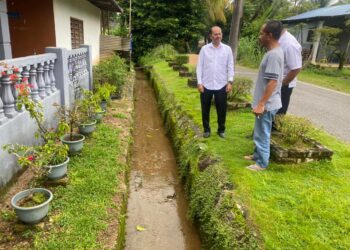 RAZALI Kassim (kiri) melakukan tinjauan di lokasi kerap berlaku banjir kilat di Felda Bukit Goh di Kuantan, Pahang. - FOTO/NORHAFIZAN ZULKIFLI