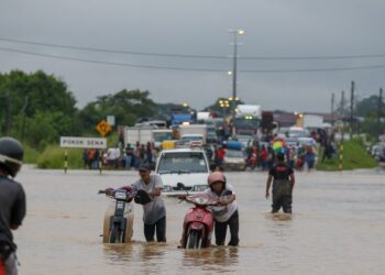 PENGGUNA jalan raya meredah air dalam kejadian banjir di pekan Pokok Sena, Alor Setar, Kedah. - UTUSAN/SHAHIR NOORDIN