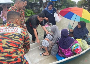 ANGGOTA keselamatan membantu memindahkan mangsa banjir membabitkan warga emas dan kanak-kanak di Kampung Chendering di Kuantan, Pahang. - FOTO IHSAN JBPM PAHANG.