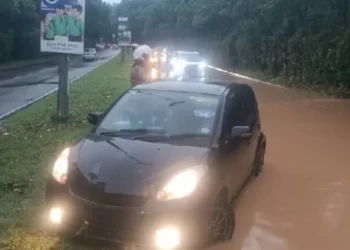 Jalan Sungai Chua di Kajang yang dinaiki air sehingga menyebabkan sebuah kereta terbabas di atas pembahagi jalan. - Gambah Ihsan Bomba