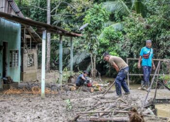 PENDUDUK membersihkan rumah dan harta benda mereka yang musnah selepas dilanda banjir kilat di Kampung Teluk Sanau, Baling, Kedah. - UTUSAN/ SHAHIR NOORDIN