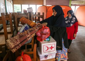 MANGSA banjir mengemas barang peribadi di PPS SK Atas Tol , Kuala Terengganu sebelum pulang ke rumah masing-masing setelah banjir surut, hari ini. - UTUSAN/PUQTRA HAIRRY ROSLI