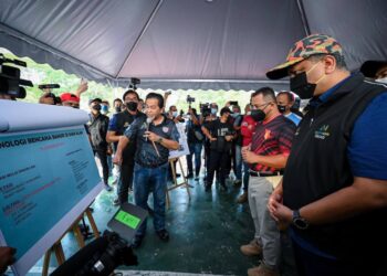 REEZAL Merican Naina Merican dan Amirudin Shari (dua dari kanan) mendengar sesi taklimat Program Mega Pembersihan Pasca Banjir di Taman Sri Muda di Shah Alam, Selangor, hari ini. - UTUSAN / ABDUL RAZAK IDRIS