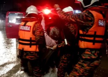 ANGGOTA Bomba Selangor membawa keluar seorang daripada mangsa yang terperangkap selepas kawasan rumahnya dinaiki air di Taman Sri Andalas, Klang awal pagi tadi.