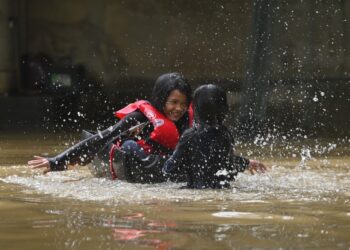 DUA beradik, Nur Irina Maria Ruzali dan Nur Aisha Alia Ruzali ceria bermain banjir di halaman rumah mereka di Kampung Nyatuh, Setiu, Terengganu. - UTUSAN/PUQTRA HAIRRY ROSLI