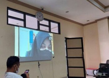 TERTUDUH ketika menjalani sesi perbicaraan secara dalam talian berhubung pertuduhan rasuah di Mahkamah Rasuah Banjarmasin.-AGENSI