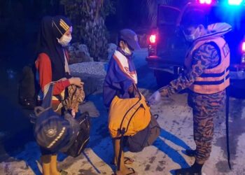 ANGGOTA bomba membantu memindahkan penduduk yang terjejas banjir di Changkat Jong, Teluk Intan malam tadi. - UTUSAN/IHSAN JBPM