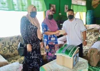 PENGERUSI Yayasan Perbandaran Pontian, Aizam Abdul Hamid (kanan) menyampaikan sumbangan kepada Jamaliah Abdullah di Lorong Atap, Jalan Bakek, Pontian, Johor.
