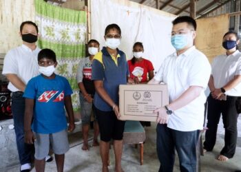 R. PUVANISWARI (dua dari kanan) menerima sumbangan kotak makanan daripada wakil MCA Perak di rumahnya di Kampung Gunung Cheroh, Ipoh, Perak. - UTUSAN/ZULFACHRI ZULKIFLI