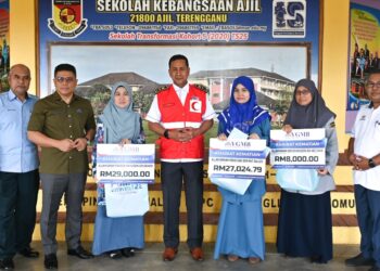 WAN Munadi Wan Mamat (dua, kiri) dan Abdul Muie Ngah (tengah) bergambar bersama waris penerima dana bantuan khairat kematian di SK Ajil, Hulu Terengganu, hari ini. - UTUSAN/PUQTRA HAIRRY ROSLI