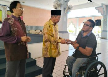 SHAIKH Harun Shaikh Ismail menyampaikan bantuan zakat sempena Ramadan kepada salah seorang asnaf fakir miskin di Terengganu dalam satu majlis di perkarangan Kompleks Pentadbiran JHEAT hari ini. - UTUSAN/KAMALIZA KAMARUDDIN