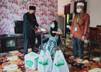 FEROZ Haniff Azmai (kiri) menghulurkan bantuan kepada Azura Ahmad di Desa Kuala Muda, Kepala Batas, Pulau Pinang, semalam.