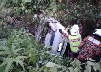 ANGGOTA bomba dan penyelamat mengeluarkan mangsa dari kereta yang terbabas dalam gaung di Kilometer 4, Jalan Lipis ke Benta berdekatan Penjom di Lipis, Pahang. -IHSAN BALAI BOMBA KUALA LIPIS