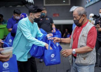 Penyanyi, Andi Bernadee (kiri) mengagihkan pek makanan bubur lambuk kepada orang ramai dalam program Kongsi Berkat Bubur Lambuk anjuran bersama EB Frozen Food Sdn. Bhd. dan Media Mulia Sdn. Bhd. di Masjid Jamek Kampung Baru, Kuala Lumpur, kelmarin. – utusan FARIZ RUSADIO