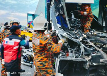 BAHAGIAN hadapan sebuah bas persiaran remuk akibat  merempuh sebuah treler di Kilometer 144.6, Lebuhraya Utara-Selatan, arah Selatan berhampiran Bukit Gambir, Tangkak.