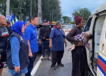 TUMINAH Kadi (kiri) dan Lim Ban Hong (kanan) menghantar bayi yang cedera dihempap pokok ru ke dalam ambulans dalam kejadian di Pantai Puteri, Melaka. 