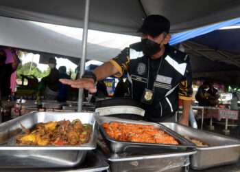 MOHD. WAZIR Khalid menunjukkan makanan tidak ditutup yang boleh menyebabkan pencemaran khususnya disebabkan lalat ketika menyertai Op Bazar di Sungai Dua, Pulau Pinang, semalam.