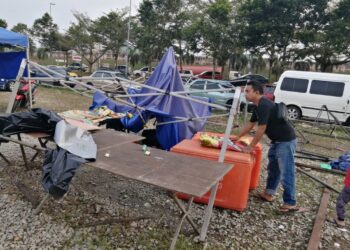 SEORANG peniaga melihat keadaan kanopi yang rosak dalam kejadian ribut di Bazar Ramadan Pekan Ajil, Hulu Terengganu, petang tadi. - UTUSAN/NOOR HAYATI MAMAT