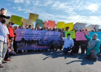 IBU bapa dan penduduk kampung berhimpun secara aman di hadapan bangunan baharu SMA Chuah di Chuah, Port Dickson hari ini bagi mendesak supaya pihak berwajib menyelesaikan masalah yang menghalang daripada bangunan baharu sekolah terbabit dapat digunakan oleh guru dan pelajar.-UTUSAN/BADRUL HAFIZAN MAT ISA.