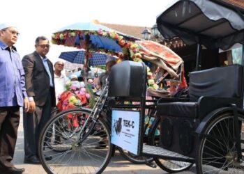 ANIZAM Abdul Rahman (kanan) melihat prototaip beca solar hibrid semasa menyampaikan bantuan sara hidup kepada penarik beca di perkarangan Pusat Penerangan Pelancongan (TIC) Kelantan.-FOTO/KAMARUL BISMI KAMARUZAMAN