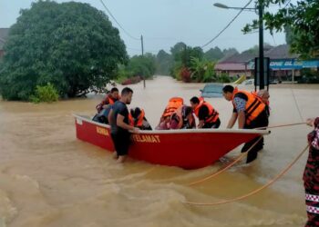 ANGGOTA bomba membantu memindahkan mangsa banjir di Kampung  Gong Baloh, Setiu, Terengganu, hari ini.