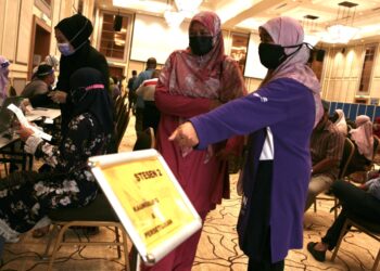 GURU KAFA yang hadir bagi menerima suntikan vaksin mendapat konsultasi dari petugas PPV ketika program vaksinasi khas bagi guru-guru KAFA, pegawai masjid, jurunikah di Selangor yang belum menerima vaksin di Dewan Syarahan Islam dan Muzakarah di Masjid Sultan Salahuddin Abdul Aziz Shah,  Shah Alam, Selangor, hari ini. - UTUSAN / ZULFADHLI ZAKI