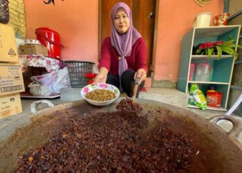 ROSLINA Mohd. Othman menunjukkan belalang masak kerutuk yang menjadi juadah istimewa pada Hari Raya Aidiladha kali ini di Kelantan. – FOTO/TOREK SULONG