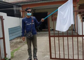 ZULKIFLIE Samsudin bersama bendera putih yang dikibarkannya sebelum ini dan mendapat perhatian ramai yang tampil membantu di Taman Pulai Indah, Kangkar Pulai, Johor.