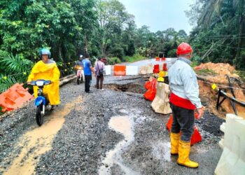 PENGGUNA motosikal melalui jalan yang berlaku mendapan ke tempat kerja berdekatan Kampung Jaya Putra, Damak di Jerantut, Pahang. - FOTO /IHSAN JPKK DAMAK