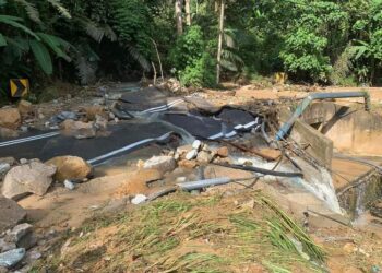 SEBAHAGIAN jalan yang rosak dan hakisan tanah akibat diterjah kepala air dalam kejadian banjir di Janda Baik di Bentong, Pahang semalam. - FOTO IHSAN JKR BENTONG