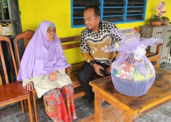 IZUDIN Muhamad Amin (kanan) menyantuni warga emas, Sopiah Basri dalam program ziarah prihatin anjuran Cancer Support Pahang (CSP) di Bera, baru-baru ini.