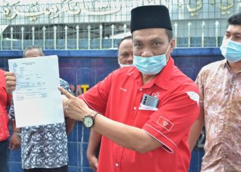 Bahari Mohamed Nor menunjukkan laporan polis yang dibuatnya berhubung satu artikel yang didakwa memfitnah Perdana Menteri di Tanah Merah, hari ini. -FOTO BAHRUDDIN HATTA