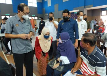 MAH Hang Soon (kiri) berbual dengan seorang pelajar ketika melawat PPV PICK Remaja di SMK Proton City di Tanjung Malim, Perak hari ini. - UTUSAN/ASLIZA MUSA