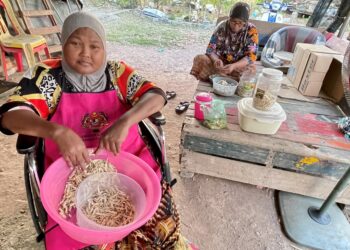 WALAUPUN penglihatan semakin kabur, Sofiah Abu Seman (kiri) gigih mengambil upah mengopek ikan bilis di rumahnya di Kampung Selarung Panjang, Kangkong di Alor Setar. -UTUSAN /JAMLIAH ABDULLAH-