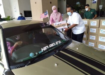 ISMAIL Othman menyampaikan sumbangan kepada seorang penerima program Kongsi Rezeki secara pandu lalu di Ayer Keroh, Melaka. - FOTO/MUHAMMAD SHAHIZAM TAZALI