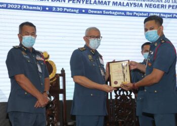MOHAMMAD Hamdan Wahid (tengah) menyampaikan Anugerah Khas Pegawai Cemerlang Berterusan Tahun 2021 kepada Muhammad Asyraf Mat Isa  pada Majlis Penyampaian Anugerah Perkhidmatan Cemerlang Tahun 2021 JBPM Negeri Perak di Ipoh, semalam. - UTUSAN/ASLIZA MUSA