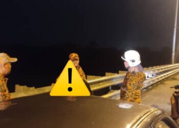 ANGGOTA bomba menenangkan seorang wanita (ditutup) selepas berjaya memujuknya daripada terjun dari Jambatan Salor, Pasir Mas, Kelantan. -  FOTO MEDIA SOSIAL