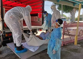 BOMBA membantu mengangkat seorang lelaki dengan berat badan 138kg di rumahnya di Umbai, Merlimau, Melaka. - UTUSAN/DIYANATUL ATIQAH ZAKARYA