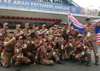 MOHAMMAD Hamdan Wahid (barisan belakang, lima dari kiri) bersama pasukan JBPM Kuala Lumpur yang dinobatkan juara keseluruhan Pertandingan Kawad Kecekapan JBPM Tahun 2022 di Marang, Terengganu, hari ini. - UTUSAN/NOOR HAYATI MAMAT