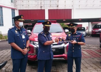 YAHAYA Madis (tengah) menyampaikan replika kunci kenderaan pacuan empat roda mengikut zon sempena Majlis Perbarisan Tahunan JBPM Johor 2022 di Johor Bahru.