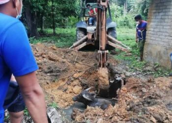 SEBUAH jengkaut digunakan untuk memecahkan pembetung dan membesarkan lubang najis untuk mengeluarkan seekor kerbau jantan di Kampung Bapong di Lipis, Pahang. - IHSAN JBPM PAHANG